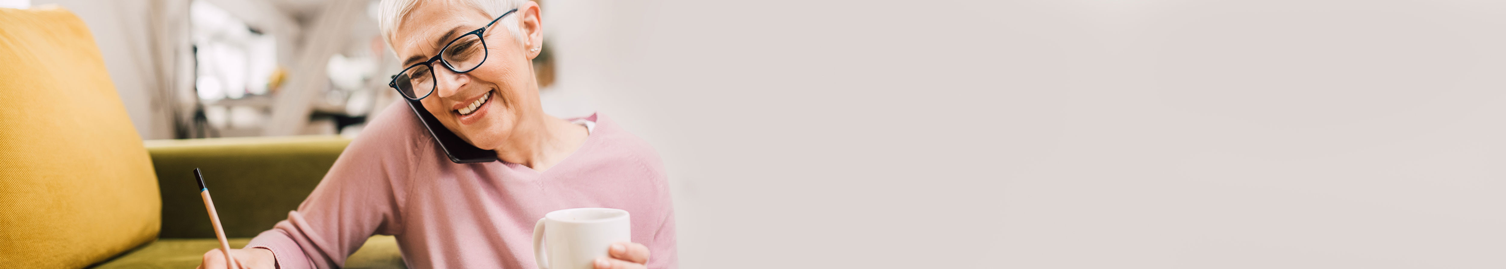 A banner of a woman talking on a phone and taking notes.