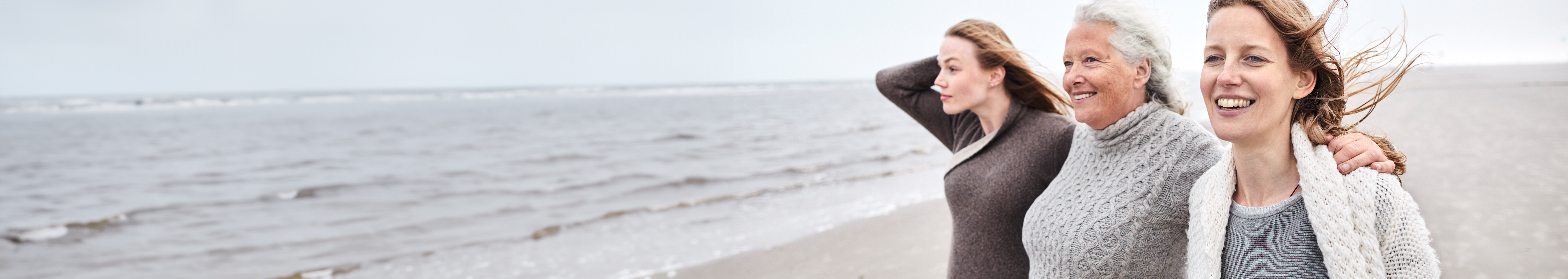 Elderly women friends laughing at a beachside.