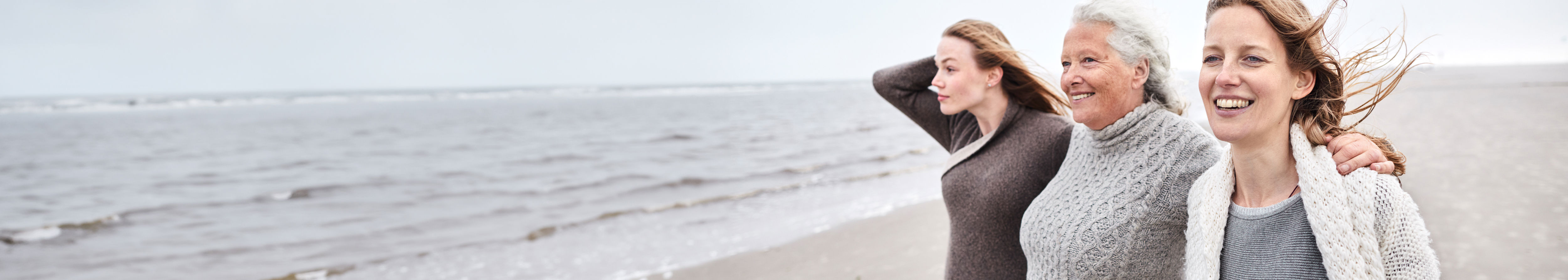 Elderly women friends laughing at a beachside.